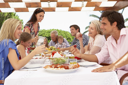 Extended Family Group Enjoying Outdoor Meal Together