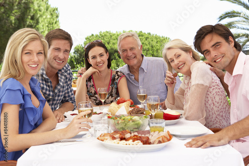 Extended Family Group Enjoying Outdoor Meal Together © Monkey Business