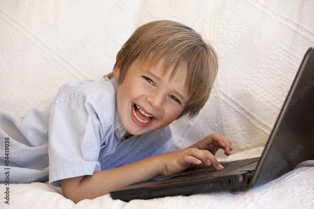 Young Boy Using Laptop At Home
