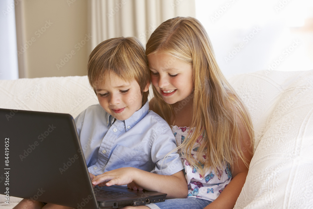 Two Young Children Using Laptop At Home Two Young Children Using Laptop At Home