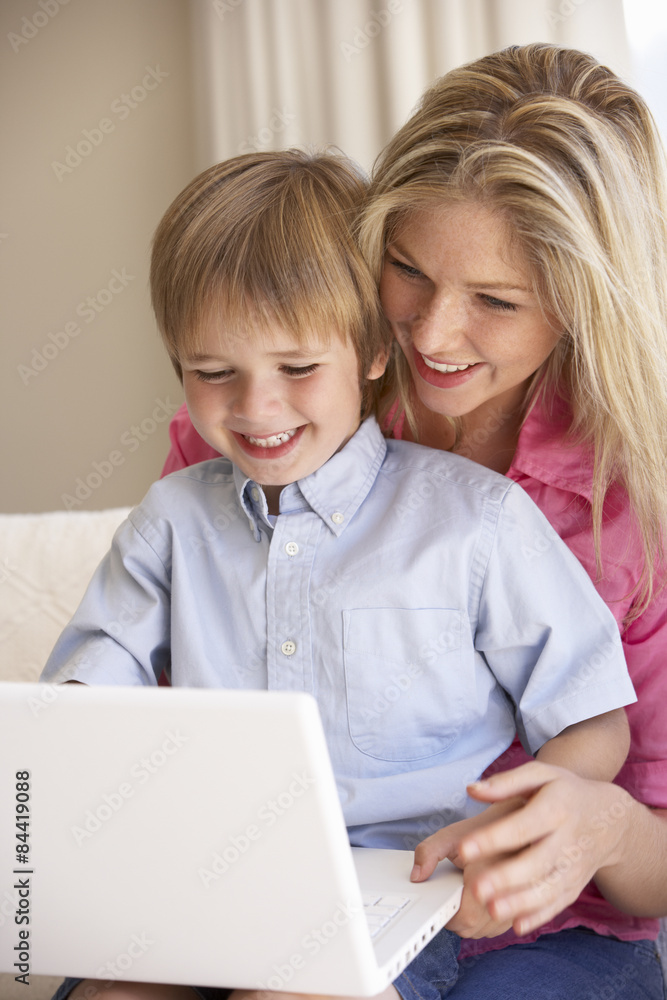 Mother And Son Using Laptop At Home