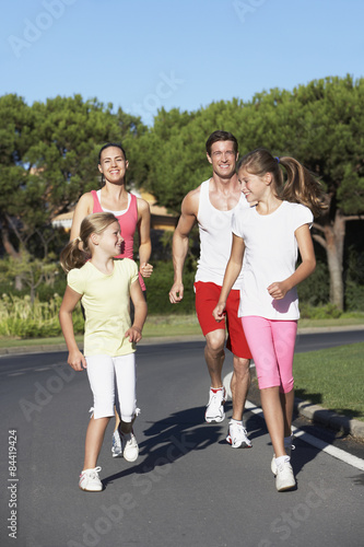 Young Family Running On Road