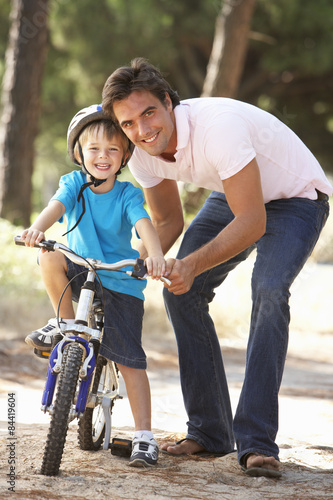Father Teaching Son To Ride Bicycle