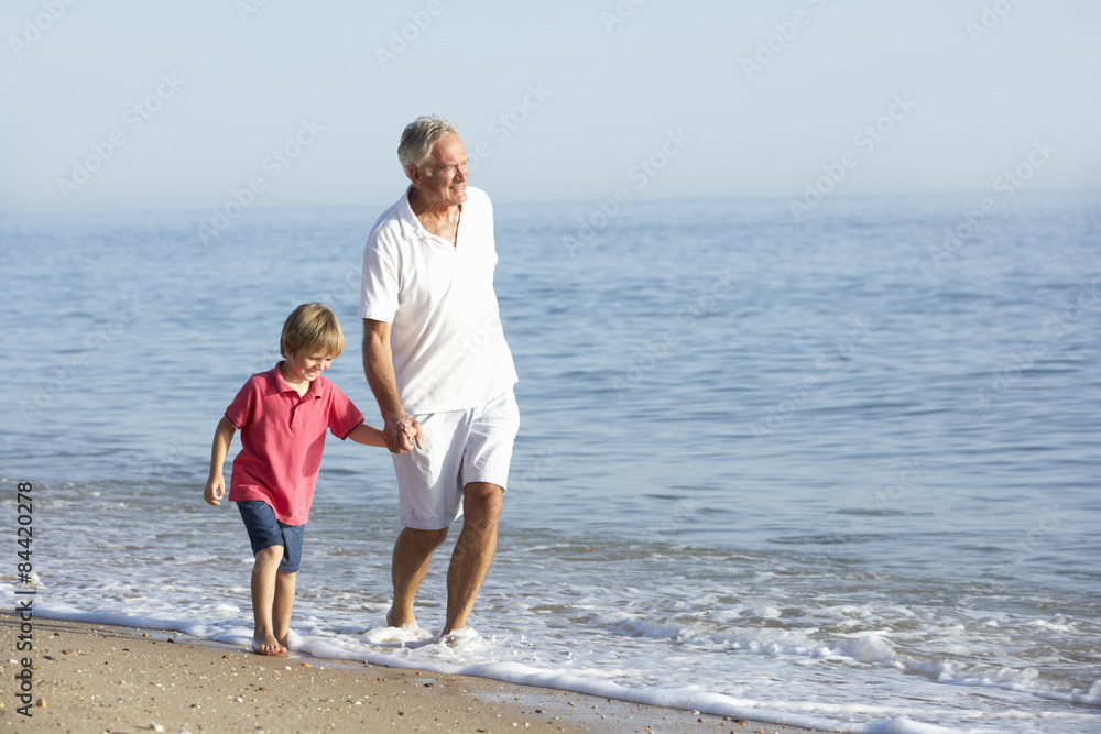 Grandfather And Grandson Enjoying Walk Along Beach Grandfather And Grandson Enjoying Walk Along Beach