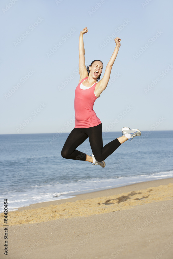Young Woman Jumping In Air On Beach