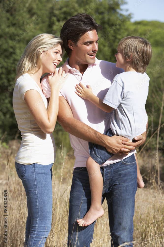 Young Family Walking Through Summer Countryside Young Family Walking Through Summer Countryside