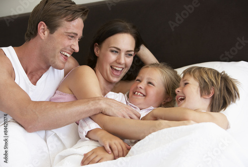 Young Family Having Fun In Bed
