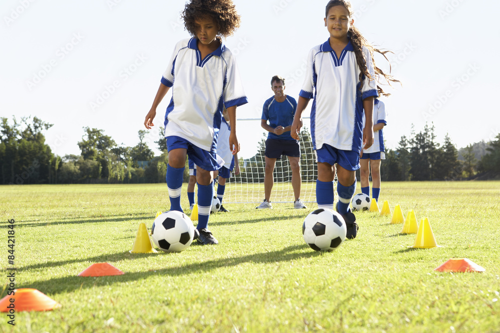 Obraz premium Group Of Children In Soccer Team Having Training With Coach