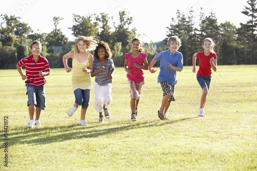 Group Of Children Running Through Countryside