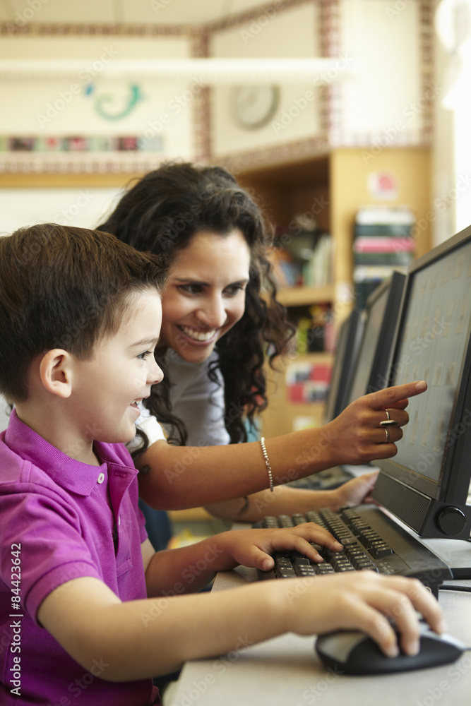 Elementary School Pupil With Teacher In Computer Class Elementary School Pupil With Teacher In Computer Class
