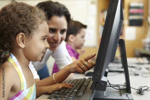 Elementary School Pupil With Teacher In Computer Class