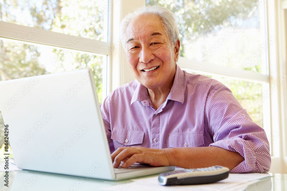 Senior Taiwanese man working on laptop Senior Taiwanese man working on laptop