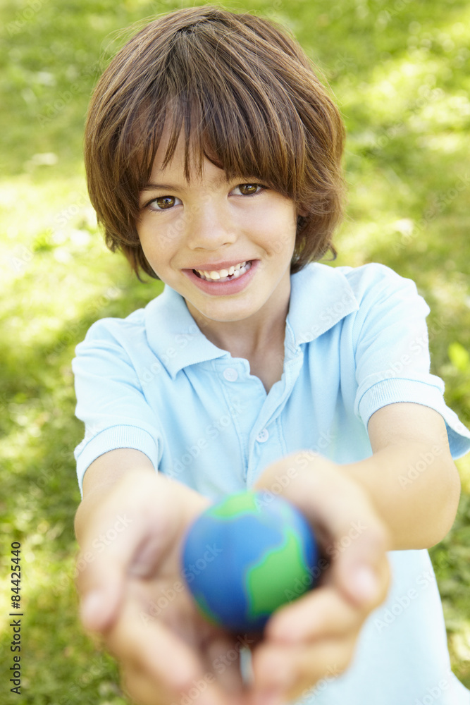 Young Boy Playing Holding Model Of Globe In Park Young Boy Playing Holding Model Of Globe In Park
