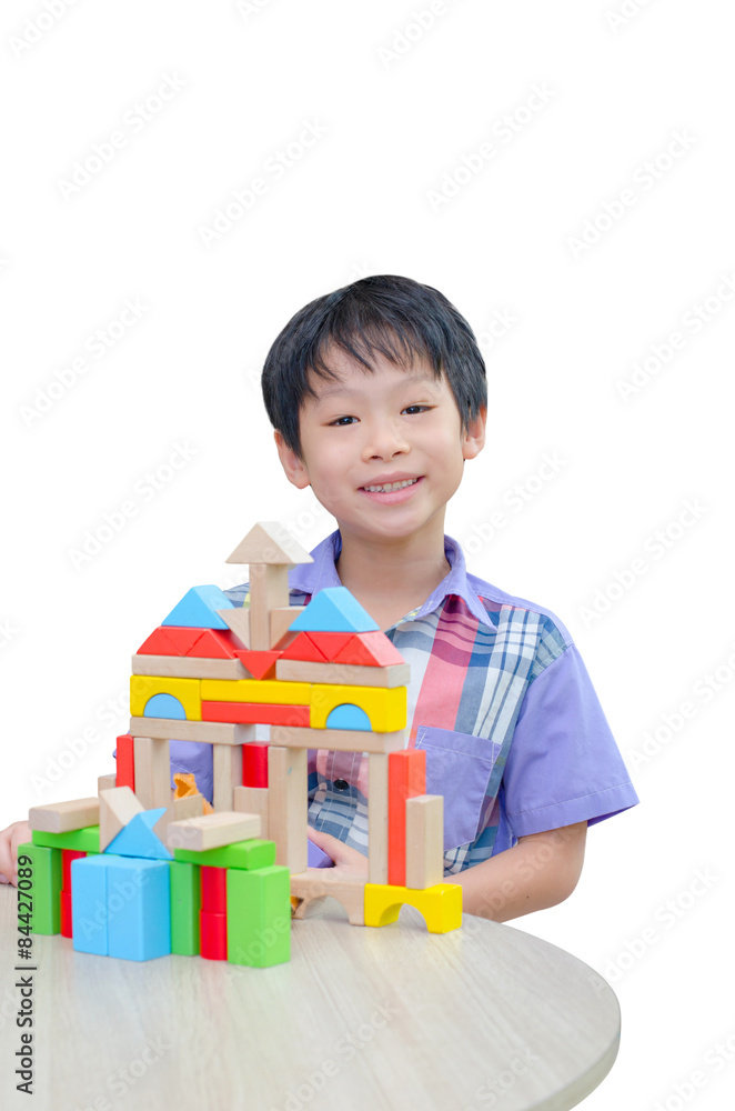 Asian boy playing blocks on table over white background Asian boy playing blocks on table over white background