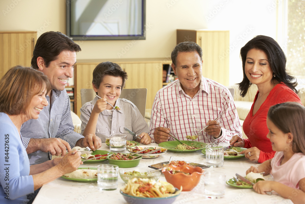 Extended Hispanic Family Enjoying Meal At Home