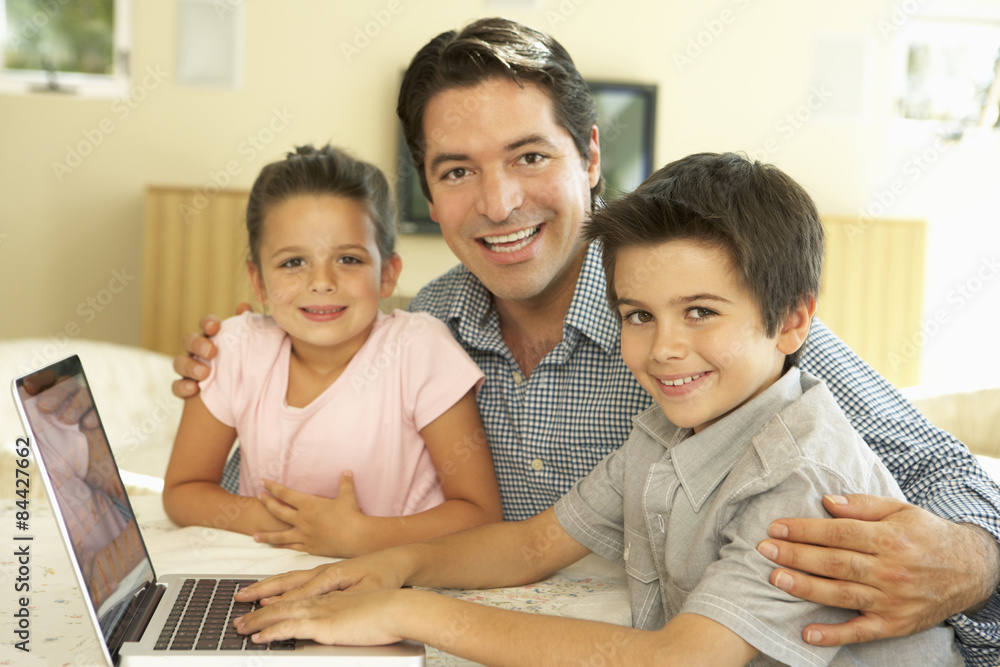Hispanic Father And Children Using Computer At Home Hispanic Father And Children Using Computer At Home