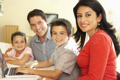 Young Hispanic Family Using Computer At Home