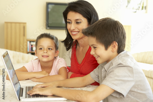 Hispanic Mother And Children Using Computer At Home