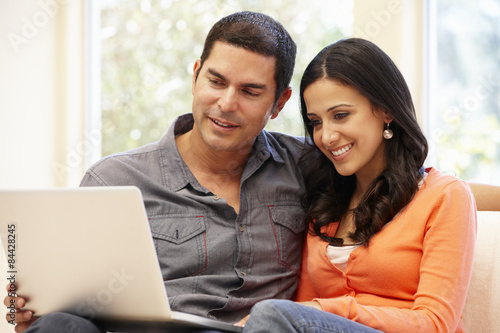 Hispanic couple at home with laptop