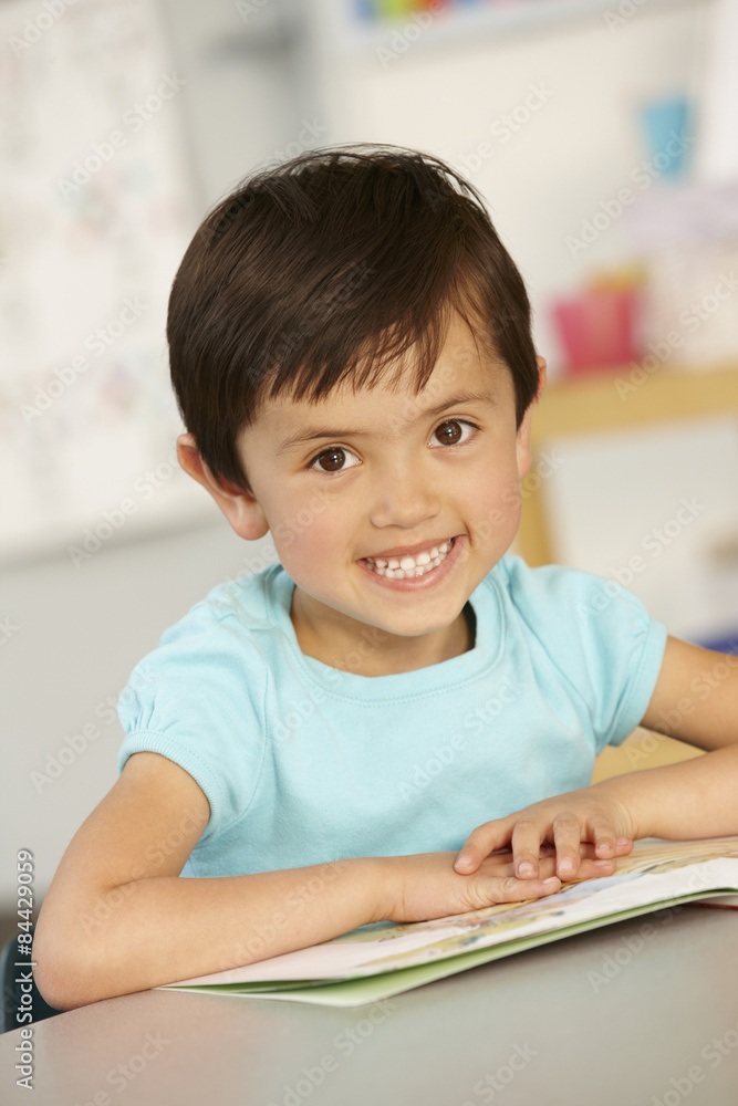 Elementary Age Schoolgirl Reading Book In Class Elementary Age Schoolgirl Reading Book In Class