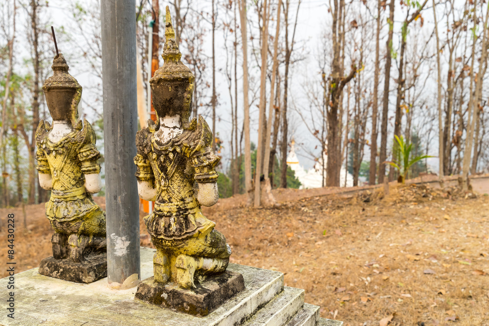 Respected angel statue with white pagoda background in Wat Phra Respected angel statue with white pagoda background in Wat Phra