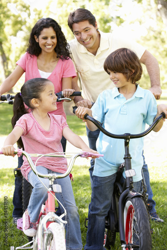 Young Hispanic Family Cycling In Park