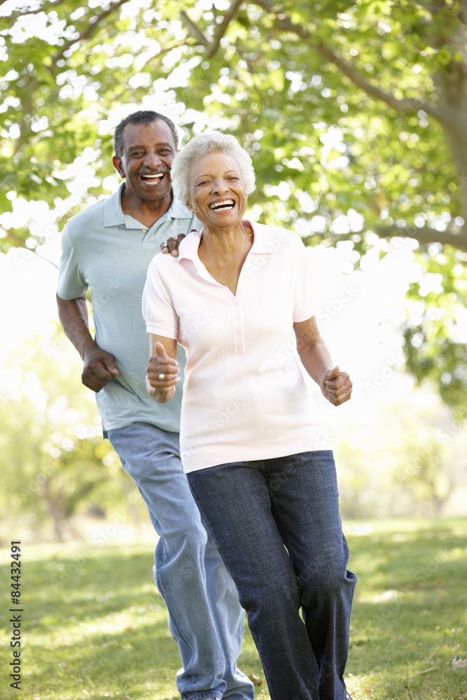 Senior African American Couple Running In Park Senior African American Couple Running In Park