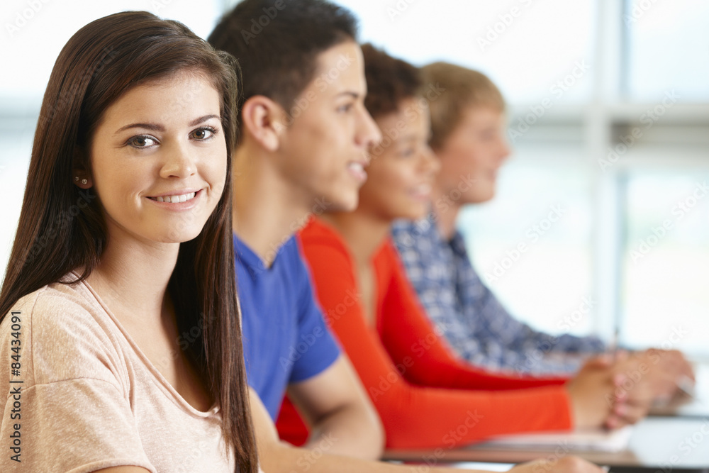Multi racial teenage pupils in class, one smiling to camera Multi racial teenage pupils in class, one smiling to camera