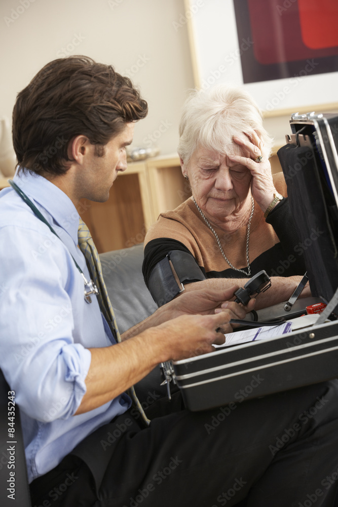 Doctor taking senior woman's blood pressure at home Doctor taking senior woman's blood pressure at home