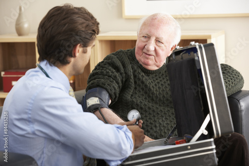 Doctor taking senior man's blood pressure at home © Monkey Business