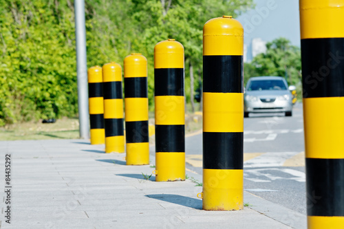 Yellow and black road safety studs with selected focus in a sunny day photo