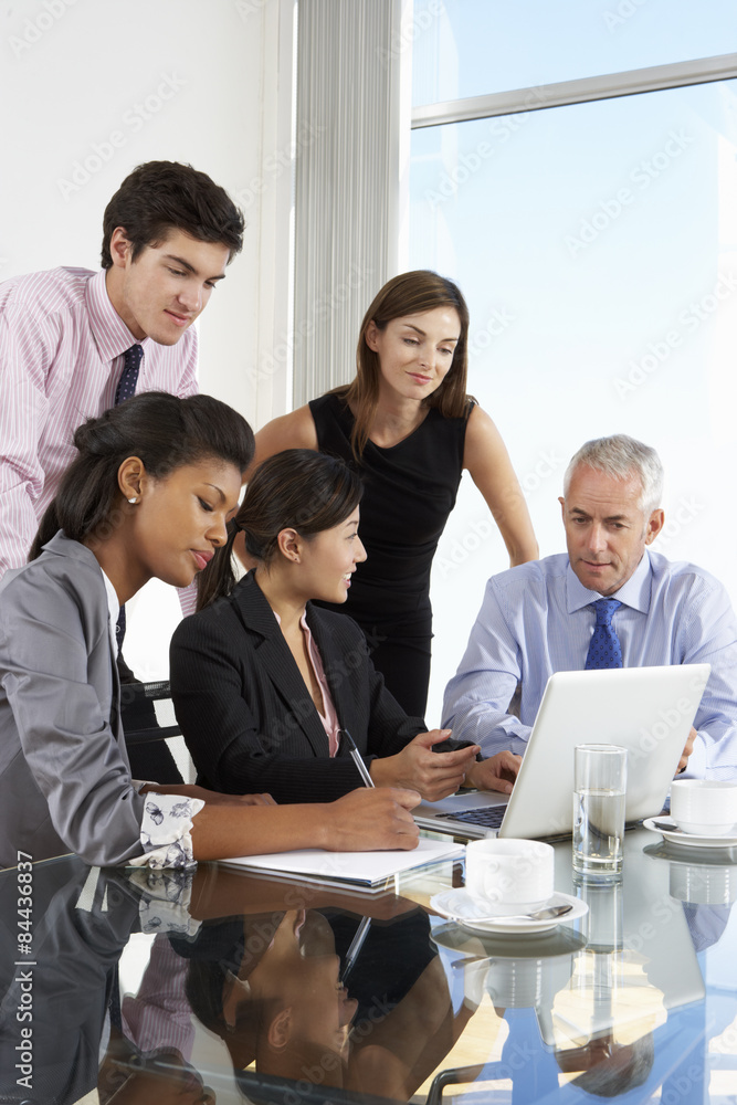 Group Of Business People Having Meeting Around Laptop At Glass Table Group Of Business People Having Meeting Around Laptop At Glass Table