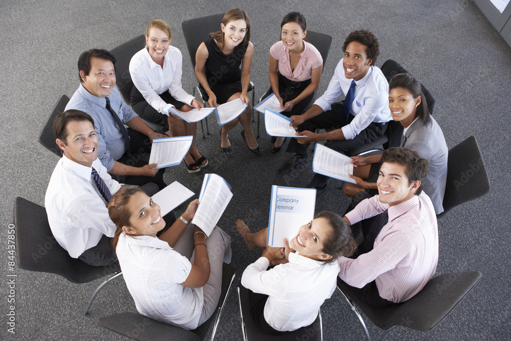 Fototapeta premium Overhead View Of Businesspeople Seated In Circle At Company Seminar