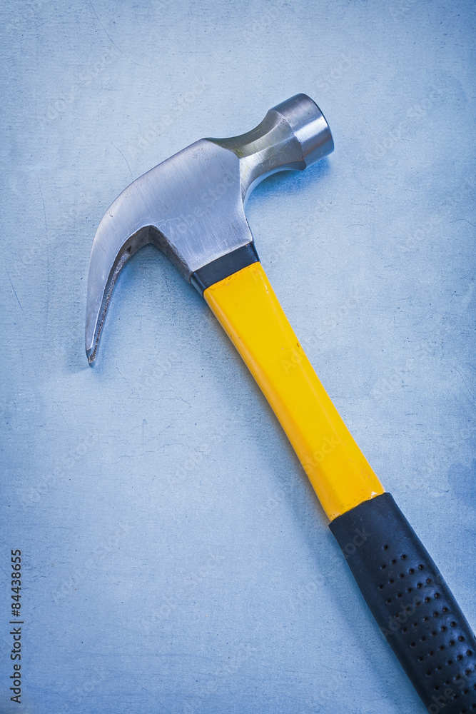 Yellow claw hammer with rubber handle on metallic background con Yellow claw hammer with rubber handle on metallic background con