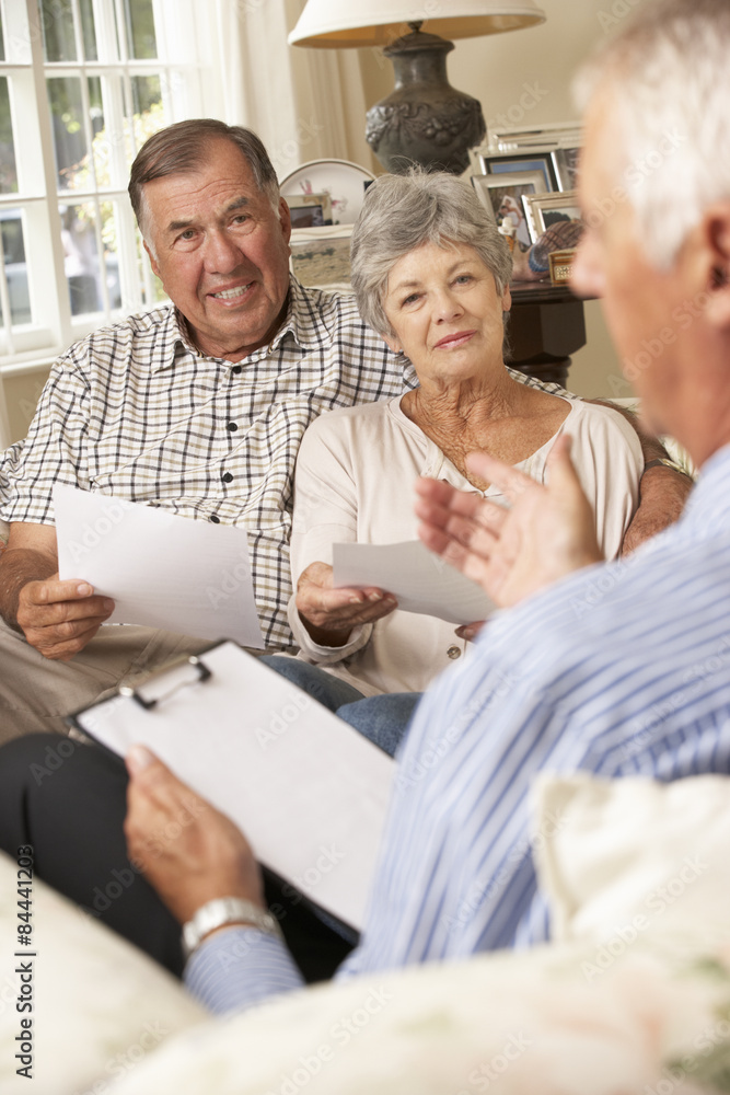 Retired Senior Couple Sitting On Sofa Talking To Financial Advisor Retired Senior Couple Sitting On Sofa Talking To Financial Advisor