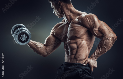 Obraz na plátně Power athletic man bodybuilder doing exercises with dumbbell