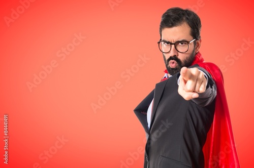 Businessman dressed like superhero pointing to the front