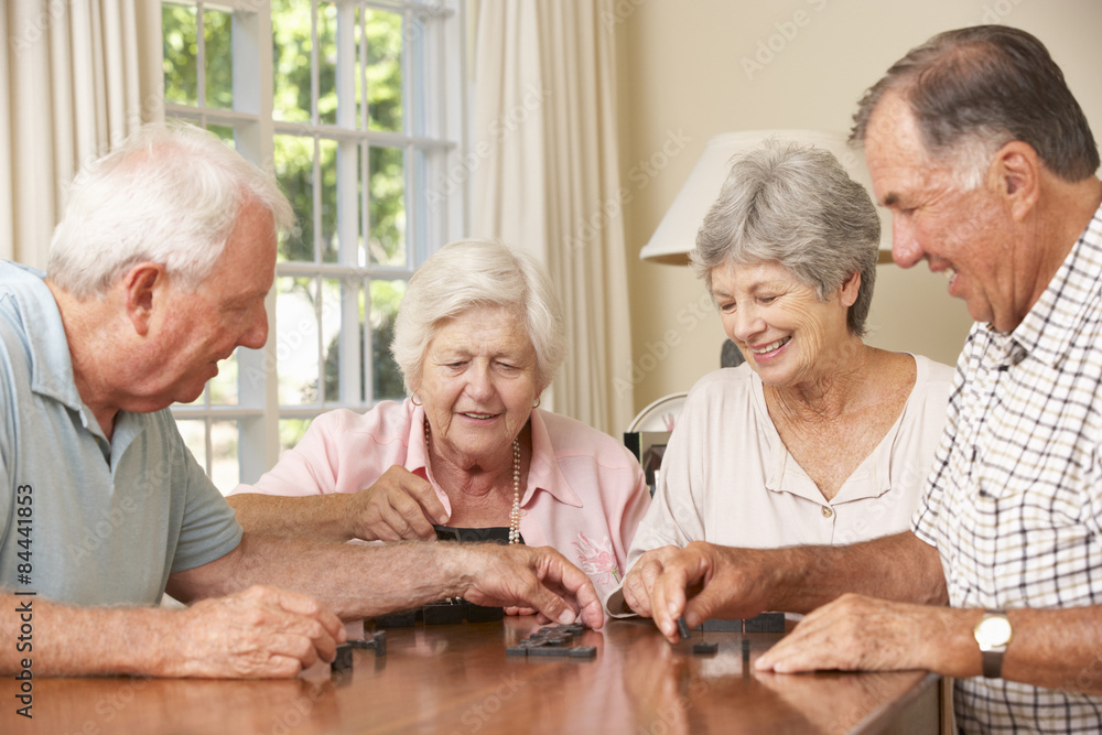 Group Of Senior Couples Enjoying Game Of Dominoes At Home Group Of Senior Couples Enjoying Game Of Dominoes At Home