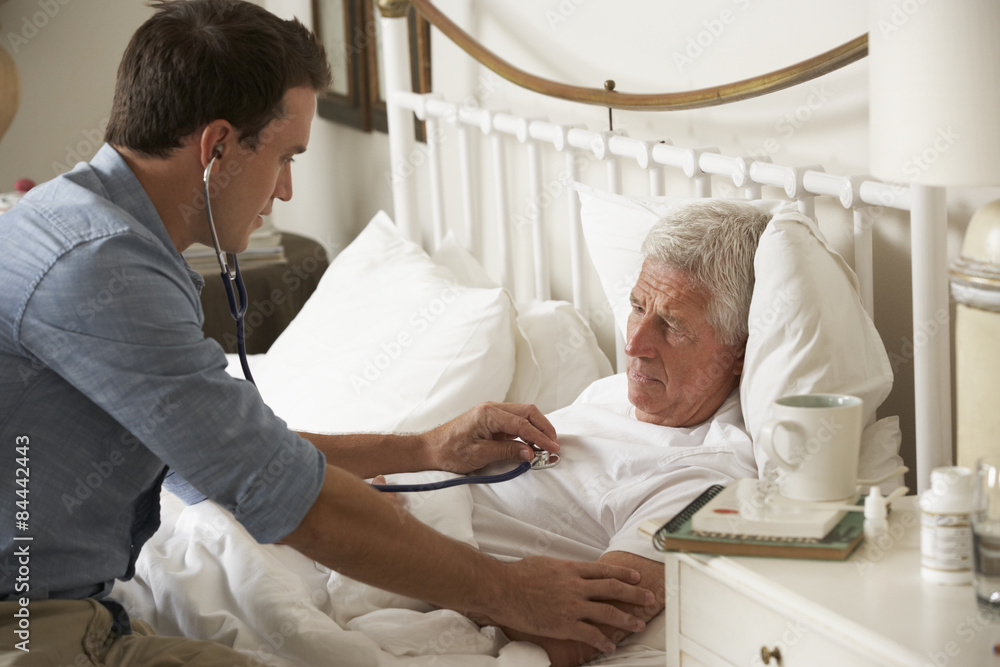 Fototapeta premium Doctor Examining Senior Male Patient In Bed At Home