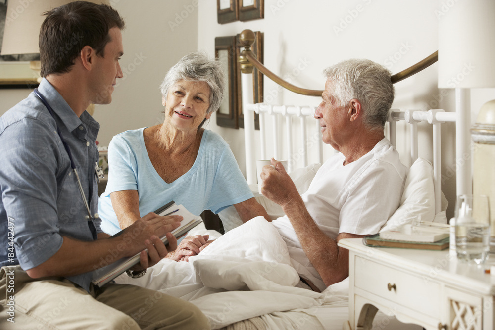 Obraz premium Doctor On Home Visit Discussing Health Of Senior Male Patient With Wife