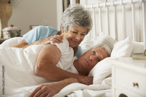 Senior Man Having Difficulty In Sleeping In Bed With Wife