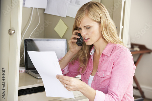 Woman Working In Home Office On Phone