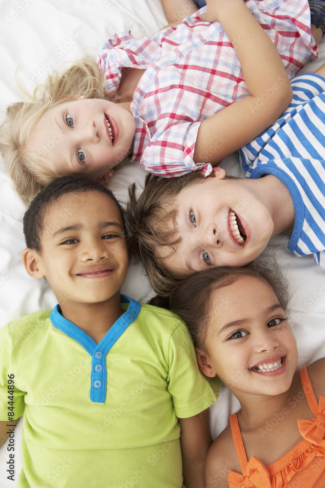 Overhead View Of Four Children Playing On Bed Together Overhead View Of Four Children Playing On Bed Together