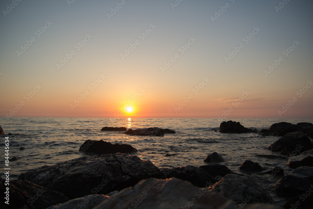 Sunset over the sea among the rocks
