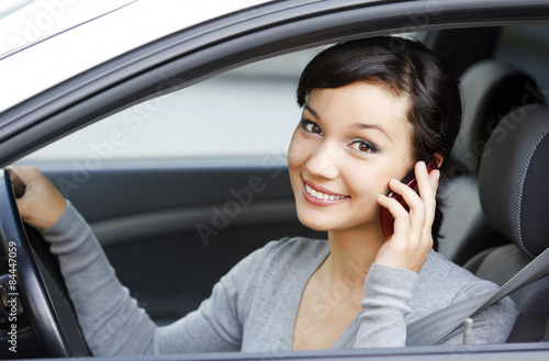 happy young woman talk on cell phone sitting in white car © Nobilior