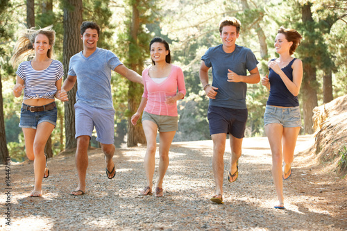 Group Of Young People Running Along Country Path