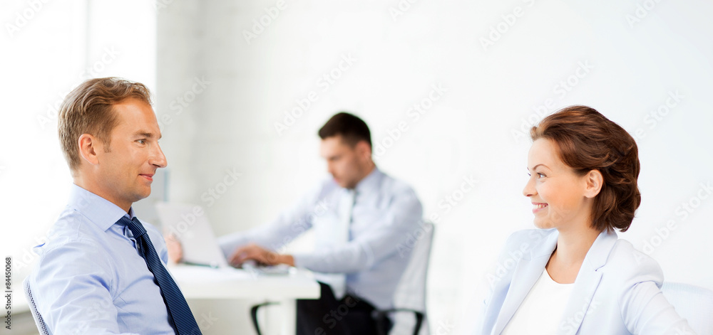 man and woman discussing something in office man and woman discussing something in office