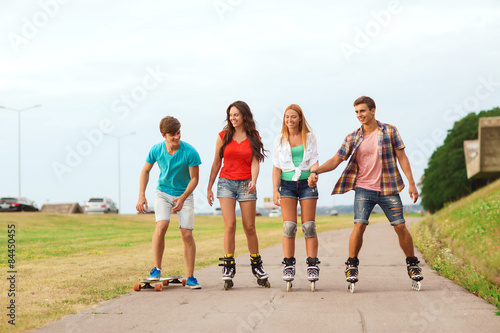 group of smiling teenagers with roller-skates