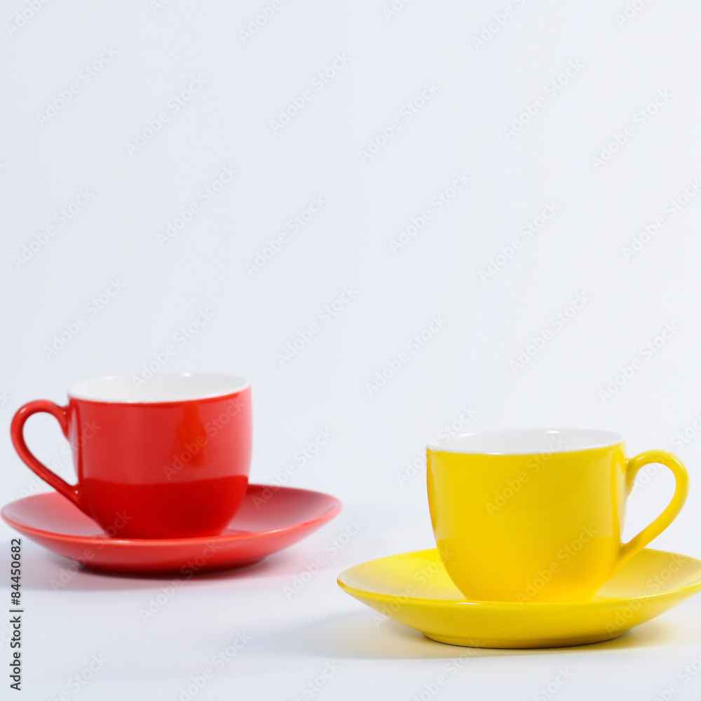Obraz premium Yellow and red cup set on table.