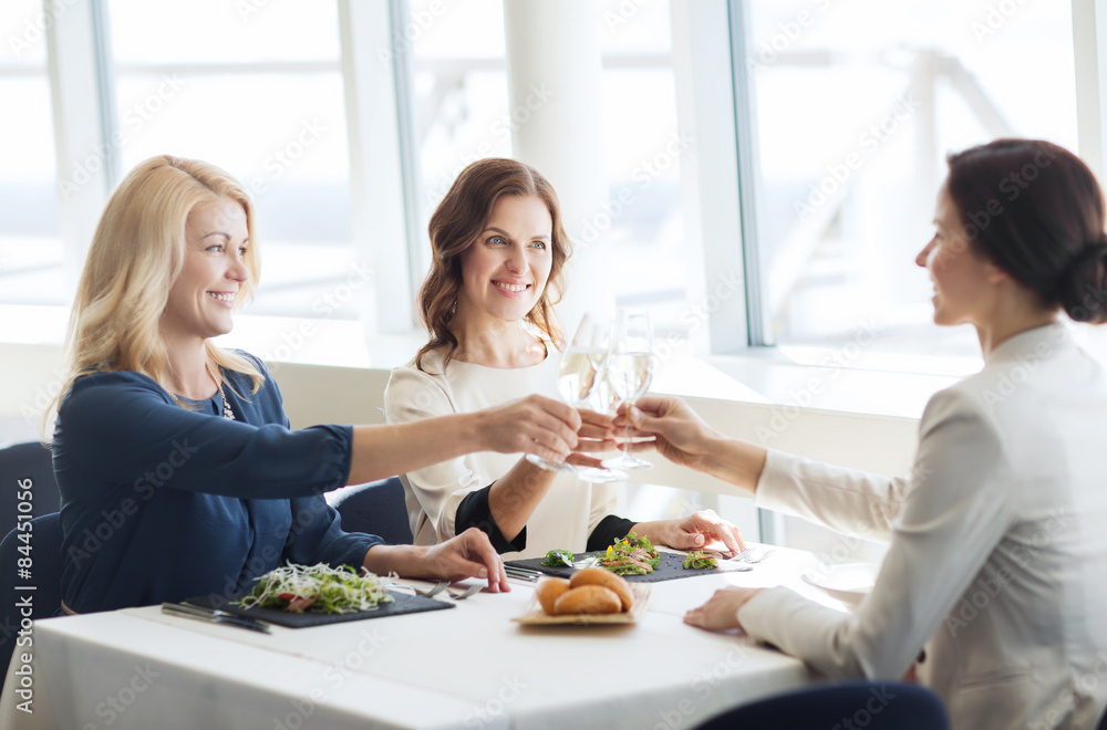happy women drinking champagne at restaurant happy women drinking champagne at restaurant